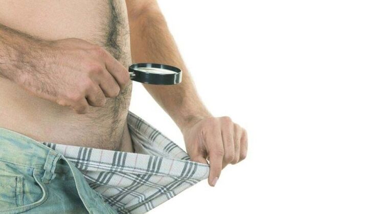 e Mann kuckt an seng Underpants an denkt un d'Erweiderung vun der Penis mat Soda